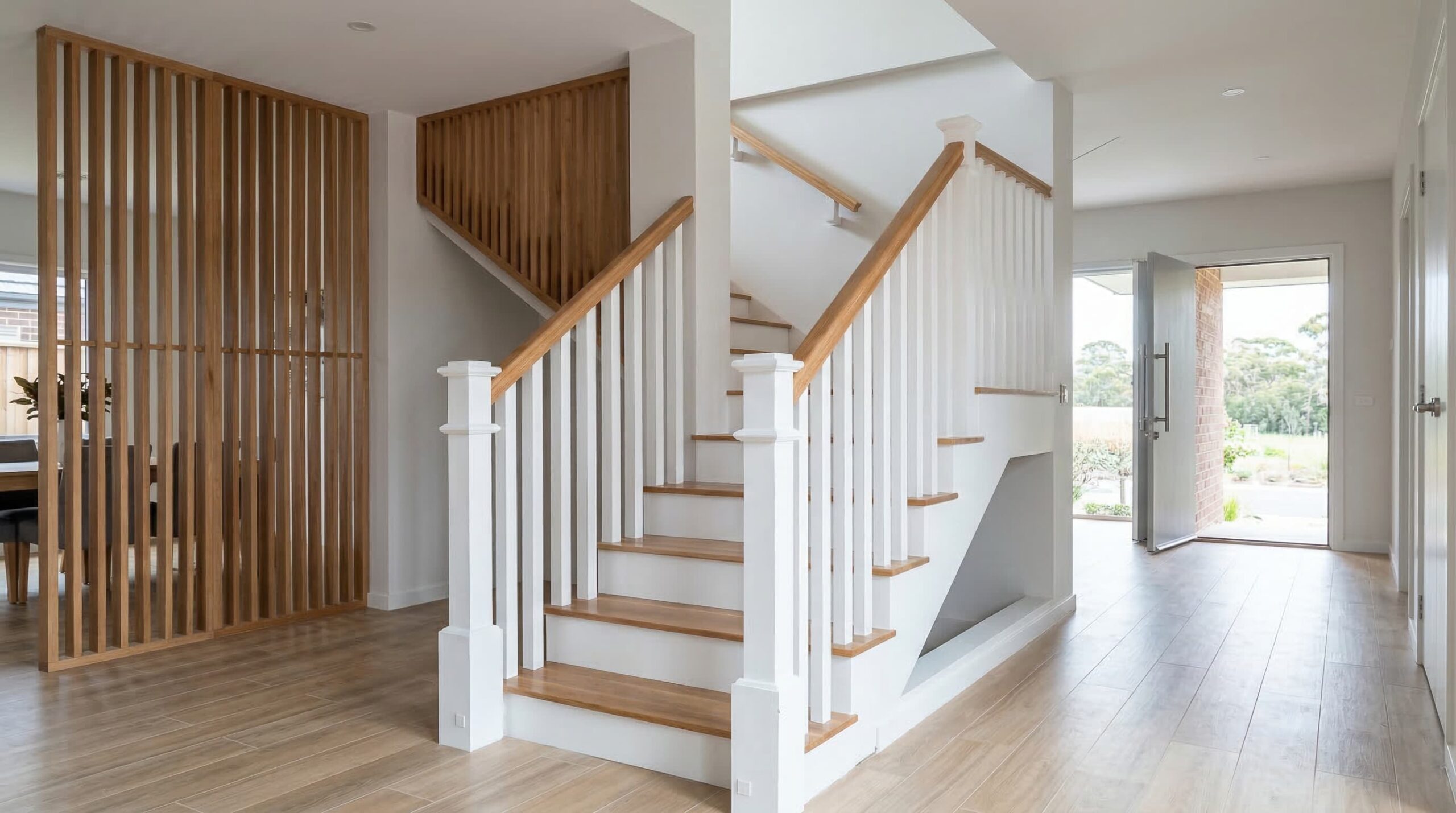 Escalera blanca de madera con estructura lateral lacada y peldaños de madera natural.