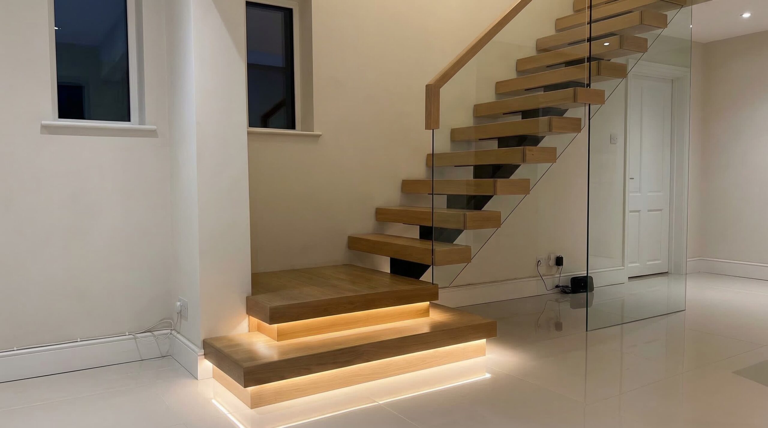 Peldaños de madera con iluminación LED inferior para mayor seguridad y diseño moderno.