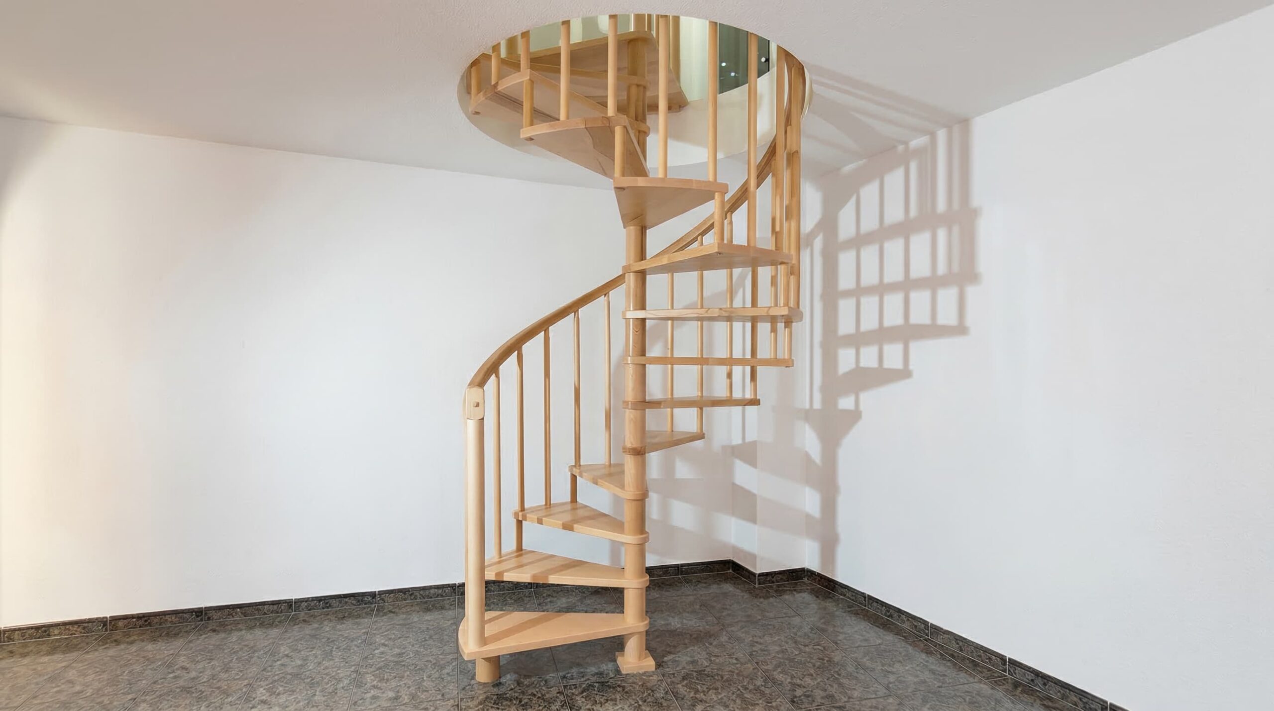 Escalera de caracol de madera maciza con barandilla curva.