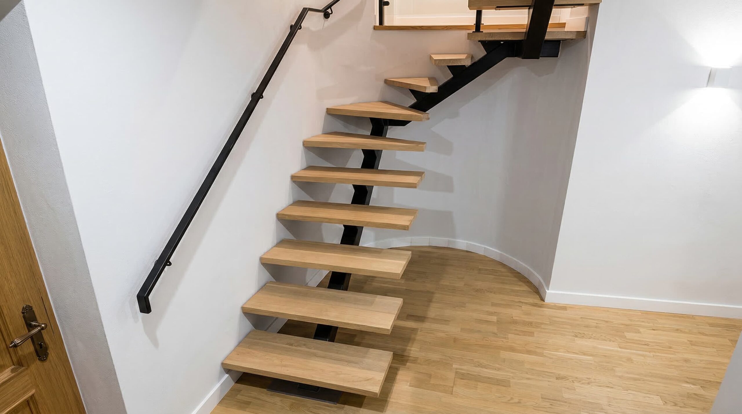 Escalera de madera y metal con estructura de hierro negro y peldaños de roble, proyecto realizado en Murcia.