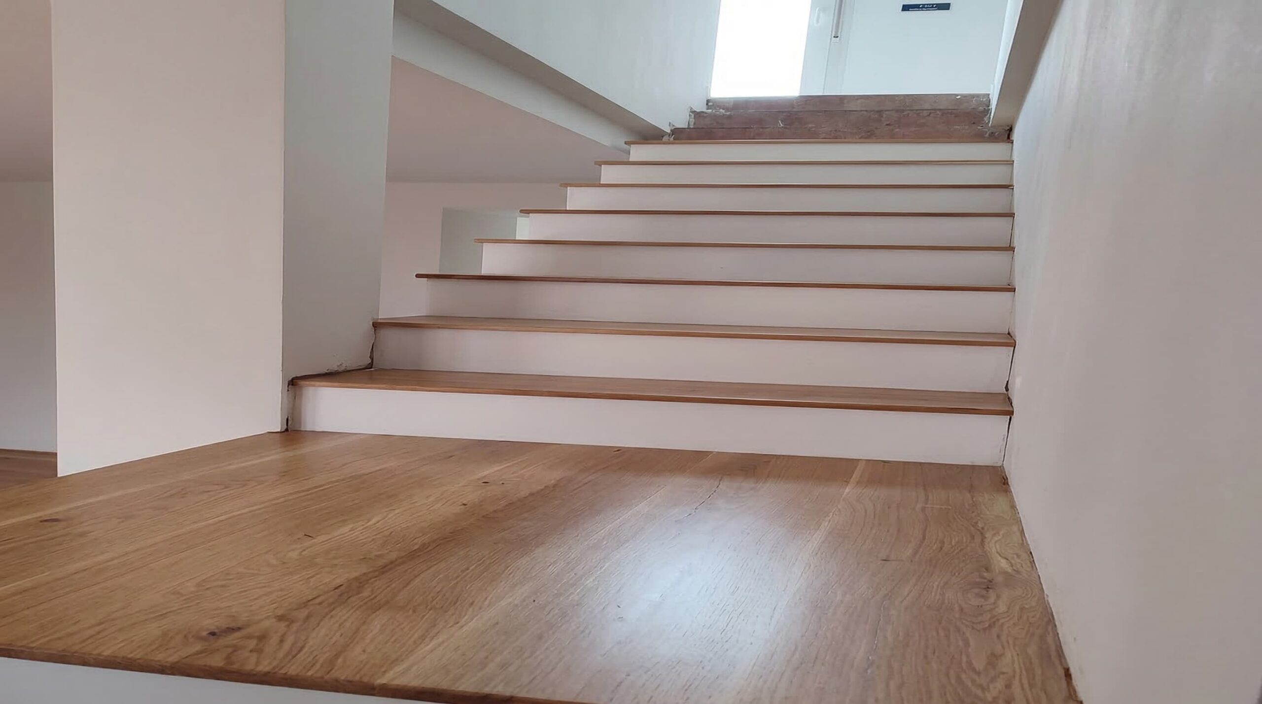 Proceso de forrado de peldaños de madera sobre una escalera de hormigón existente.