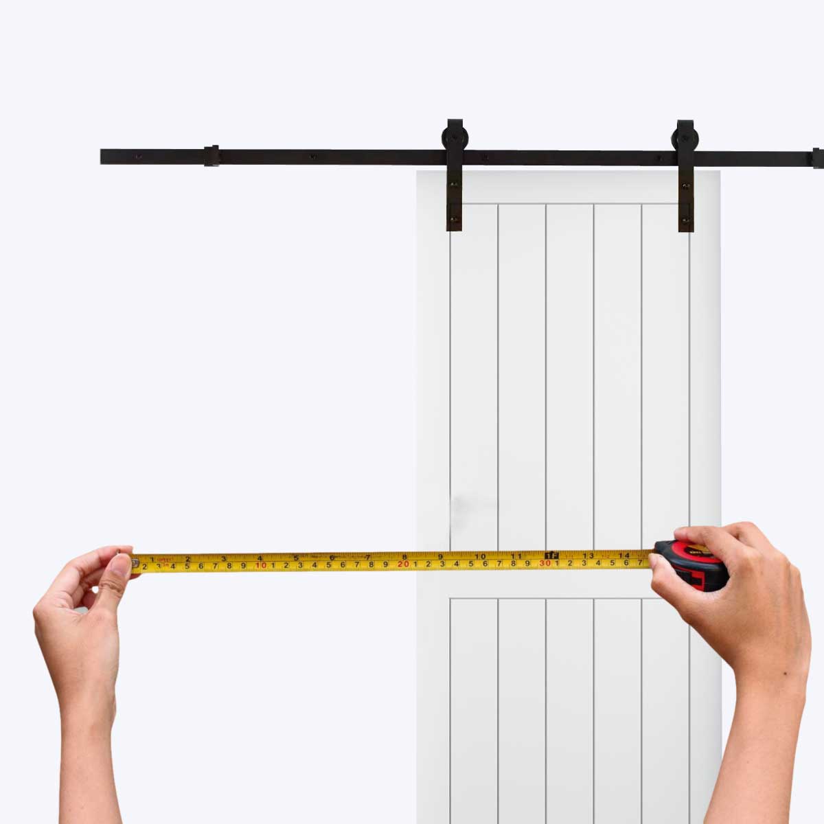 unas manos tomando medidas a una puerta corredera de granero