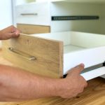 manos carpintero instalando cajones canteados
