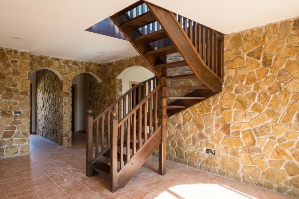 Escalera de madera artesana terminada en color nogal con acabados de alta precisión.