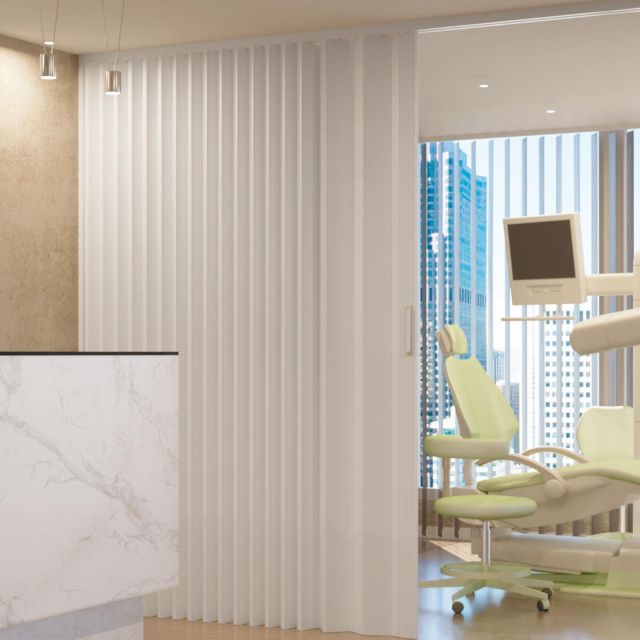 puerta plegable blanca instalada en consultorio médico