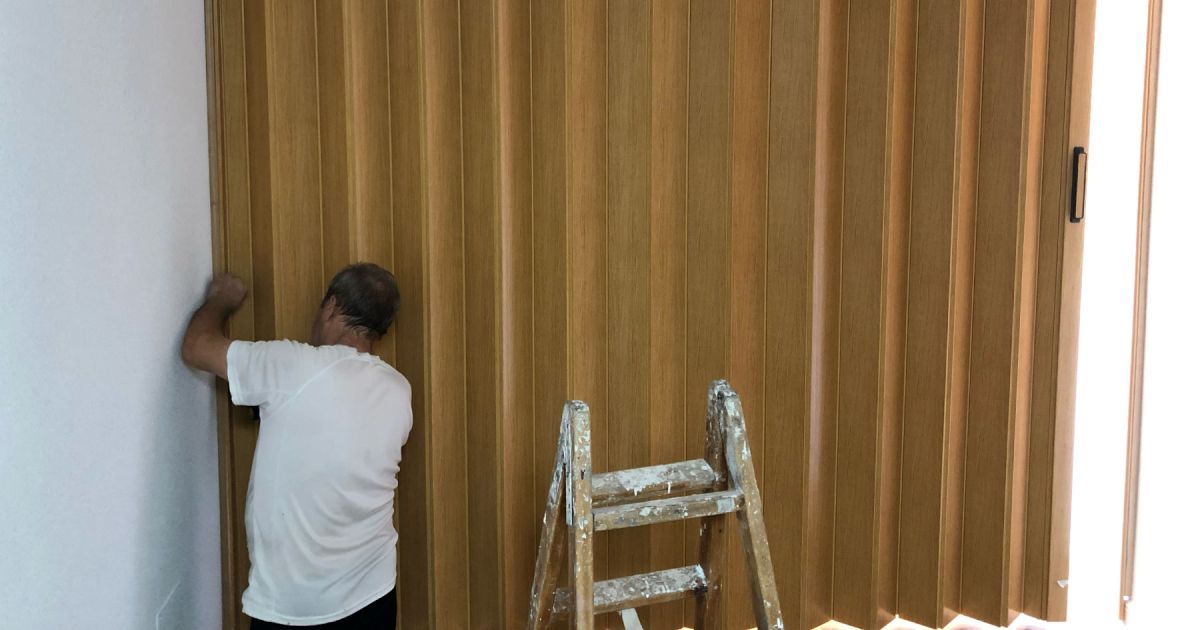 carpintero instalando una puerta plegable de color roble