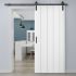 puerta corredera de granero blanca instalada en una habitacion moderna que tiene un suelo de madera