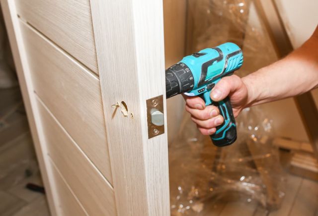 hombre instalando manija puerta maciza